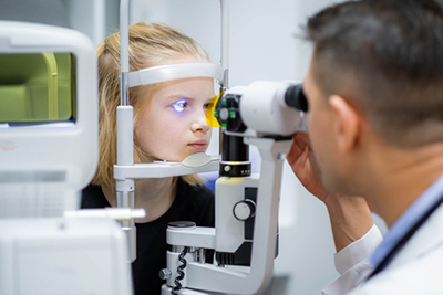 Child with autism undergoing vision screening with optometrist